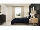 Relaxing bedroom showcasing a plush bed, a sunlit window with curtains, and dark accent wall at 36017 Joseph Blake St, Zephyrhills, FL 33541