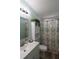 Bathroom with sink, vanity, and toilet showing a tropical patterned shower curtain at 37643 Campo Ave, Zephyrhills, FL 33541