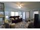 Cozy living room features a comfortable sofa, ceiling fan, and a sliding glass door at 37643 Campo Ave, Zephyrhills, FL 33541
