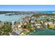 Picturesque aerial view of a waterfront community with a private dock, a pool, lush greenery, and charming homes at 425 12Th Ave, Indian Rocks Beach, FL 33785