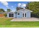 A bright blue home with a manicured lawn, features a sliding glass door and charming double doors to bring the outside in at 425 12Th Ave, Indian Rocks Beach, FL 33785