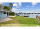 Waterfront backyard with lush lawn, boat dock, and beautiful lake view at 425 12Th Ave, Indian Rocks Beach, FL 33785