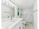 Bright bathroom featuring a marble-look tiled shower, modern fixtures, and a vanity with a quartz countertop at 425 12Th Ave, Indian Rocks Beach, FL 33785