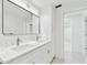 Bathroom with marble countertops, dual sinks, and updated light fixture and storage at 425 12Th Ave, Indian Rocks Beach, FL 33785
