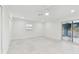 Bright and airy bedroom with white color scheme, ceiling fan, large window, and sliding glass door to lanai at 425 12Th Ave, Indian Rocks Beach, FL 33785