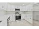 Well-lit kitchen showcases stainless steel appliances and modern white cabinetry at 425 12Th Ave, Indian Rocks Beach, FL 33785