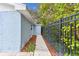A walkway extends along a blue home featuring a black metal fence, offering a secure and private outdoor space at 425 12Th Ave, Indian Rocks Beach, FL 33785