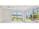 Bright sunroom with floor to ceiling glass doors overlooking the water and green grass at 425 12Th Ave, Indian Rocks Beach, FL 33785