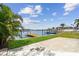 Lush tropical foliage frames a view of a private dock and serene waters, enhancing the waterfront property's appeal at 425 12Th Ave, Indian Rocks Beach, FL 33785