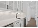 Wet bar area with glass cabinets, a wine cooler, marble countertops, and stylish fixtures at 429 Erie Ave, Tampa, FL 33606