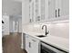 Modern bar area with glass cabinets, a wine cooler, marble countertops, and stylish fixtures at 429 Erie Ave, Tampa, FL 33606