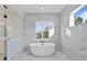 Bright bathroom featuring a freestanding tub, frameless shower, and window with natural light at 429 Erie Ave, Tampa, FL 33606