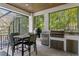 A stylish, covered patio with a grill, dining set, and seating offer an inviting outdoor space at 429 Erie Ave, Tampa, FL 33606
