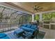 An elegant, covered patio provides a comfortable seating area, dining table, grill, and views of tropical landscaping at 429 Erie Ave, Tampa, FL 33606
