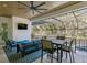 A covered patio includes outdoor seating, a ceiling fan, and an enclosed pool with lush landscaping views at 429 Erie Ave, Tampa, FL 33606