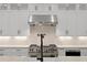 Modern white kitchen with marble backsplash, stainless steel appliances, and ample cabinetry at 429 Erie Ave, Tampa, FL 33606