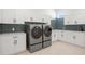 Spacious laundry room with modern washer and dryer, gray backsplash, and ample cabinet space at 429 Erie Ave, Tampa, FL 33606