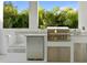 The outdoor kitchen boasts a stainless grill, a beverage cooler, and granite countertops for food preparation at 429 Erie Ave, Tampa, FL 33606