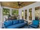 Cozy outdoor seating area featuring a grill, dining table and ceiling fan under a wood ceiling at 429 Erie Ave, Tampa, FL 33606