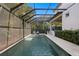 A screened pool and patio are showcased against a backdrop of blue sky and lush tropical foliage at 429 Erie Ave, Tampa, FL 33606