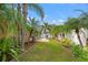 Green backyard with a manicured lawn and tropical landscaping at 4410 Foxboro Dr, New Port Richey, FL 34653