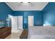 Bright bedroom boasting blue walls, two closets, light-colored floors, and a glimpse into an attached bathroom at 4410 Foxboro Dr, New Port Richey, FL 34653