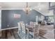 Open dining area with a wood table, white chairs, and a modern chandelier, flowing into a cozy living room at 4410 Foxboro Dr, New Port Richey, FL 34653