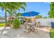 Outdoor dining with covered patio adjacent to a swimming pool under a vibrant blue umbrella at 4721 W Lawn Ave, Tampa, FL 33611