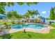 Inviting backyard oasis featuring a sparkling pool, a paver patio, manicured lawn, and tropical palm trees at 4721 W Lawn Ave, Tampa, FL 33611