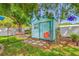 Charming backyard shed with custom tropical paint and lush landscaping, perfect for storage at 4721 W Lawn Ave, Tampa, FL 33611