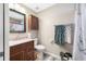This is a full bath featuring a granite vanity, framed mirror, commode, and shower with curtain at 4721 W Lawn Ave, Tampa, FL 33611
