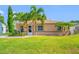 Charming single-story home with a lush green lawn, tropical landscaping, and a welcoming walkway to the front door at 4721 W Lawn Ave, Tampa, FL 33611