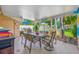 Outdoor patio with covered dining area, lush landscaping, and pool views, great for entertaining guests at 4721 W Lawn Ave, Tampa, FL 33611