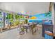 Inviting covered patio with comfortable dining and lounging areas, featuring a vibrant beach-themed mural backdrop at 4721 W Lawn Ave, Tampa, FL 33611