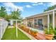Serene backyard featuring a screened-in patio area, lush grass, and white fencing at 509 N Walker St, Plant City, FL 33563