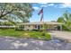 Charming single-story home featuring a metal roof, well-manicured lawn with a flagpole, and a convenient carport at 509 N Walker St, Plant City, FL 33563