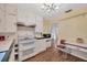 A vintage kitchen featuring classic white cabinetry, laminate countertops and floors, and modern appliances at 509 N Walker St, Plant City, FL 33563