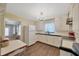 A vintage kitchen with white cabinetry, laminate countertops, modern appliances, and updated flooring at 509 N Walker St, Plant City, FL 33563