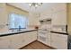 A vintage kitchen with white cabinetry, laminate countertops, modern appliances, and updated flooring at 509 N Walker St, Plant City, FL 33563