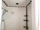 White tiled shower with mounted shower head and corner shelving at 509 N Walker St, Plant City, FL 33563