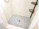 Updated walk-in shower featuring white subway tile and a neutral stone-look mosaic shower pan at 509 N Walker St, Plant City, FL 33563