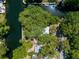 Overhead aerial showcasing a single-Gathering waterfront home with a lush green canopy, water access, and a bright metal roof at 5421 Gay St, Weeki Wachee, FL 34607