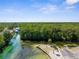 Aerial view showcases the river and boat launch, with a backdrop of lush, dense greenery and clear blue skies at 5421 Gay St, Weeki Wachee, FL 34607
