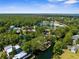 Wide aerial shows a coastal community where canals meet the water, lined with homes and verdant trees at 5421 Gay St, Weeki Wachee, FL 34607