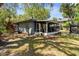 Landscaped backyard featuring a screened porch addition, mature trees, and a well-maintained lawn at 5421 Gay St, Weeki Wachee, FL 34607