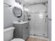 Stylish bathroom with a glass-enclosed shower, gray vanity, and modern fixtures at 5421 Gay St, Weeki Wachee, FL 34607