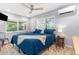 Comfortable bedroom featuring a large window, ceiling fan, and a cozy blue bed at 5421 Gay St, Weeki Wachee, FL 34607