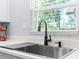 Modern kitchen sink with stainless steel appliances and a view of the outdoors through the window at 5421 Gay St, Weeki Wachee, FL 34607