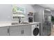 Modern kitchen with stainless steel appliances, washer/dryer combo, and bright natural light from the window at 5421 Gay St, Weeki Wachee, FL 34607
