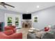 Bright living room featuring a fireplace, two chairs, a gray couch, and double doors that lead to an outdoor area at 5421 Gay St, Weeki Wachee, FL 34607